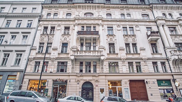 A historic building with ornate architecture, multiple floors, and a central entrance with a large door. - CAMŌ ROOMS - Boutique Aparthotel (Prague)