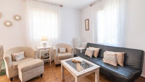 A living room with a sofa, armchairs, a coffee table, and a side table.