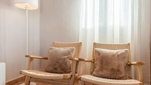 Two wicker chairs with matching cushions in a room with a floor lamp and sheer curtains. - Villa Francisco Torrox by Ruralidays (Málaga)