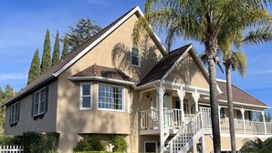 A two-story house with a front porch, a staircase, and a small garden area.