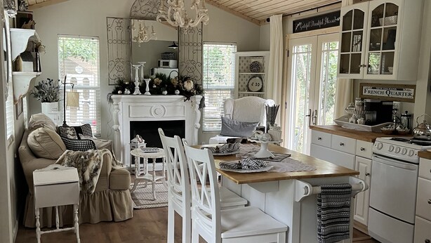 A cozy kitchen with a central island, white cabinetry, and a vintage stove.