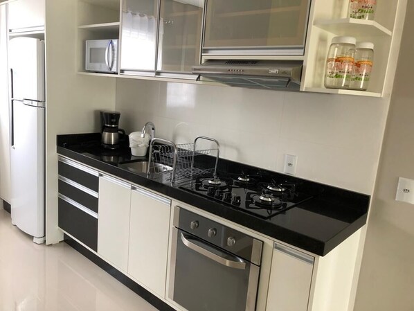 Enjoy cooking in this well-equipped kitchen with a gas stove, microwave, and oven, plus a coffee maker and dish rack.