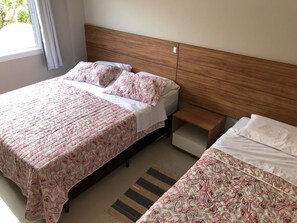 Restful retreat with a large bed, wooden headboard, and nightstand.