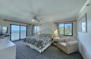 Relax in this inviting room with a large bed, TV, desk, and comfortable chair.