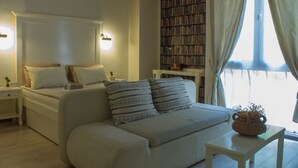 Una camera accogliente con un letto, un comodino, una mensola portaoggetti e una finestra con tende.