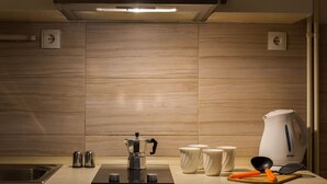 Una cucina moderna con piano cottura integrato, una macchina per il caffè e un bollitore sul bancone.