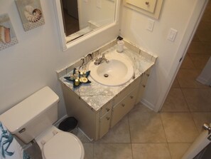 A bathroom with a toilet, sink, and mirror. There is a star-shaped soap dish on the sink counter. - WALK TO BEACH ACCESS! DOG FRIENDLY PROPERTY! (Englewood)