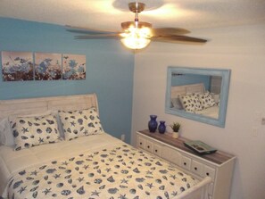 A bedroom with a bed, a ceiling fan, a dresser, and a mirror. - WALK TO BEACH ACCESS! DOG FRIENDLY PROPERTY! (Englewood)