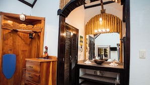 A bathroom with a wooden vanity, a sink, and a mirror.