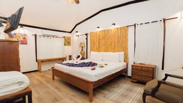 Un dormitorio con cama de madera, mesita de noche de madera, una silla, un escritorio y un ventilador de techo.