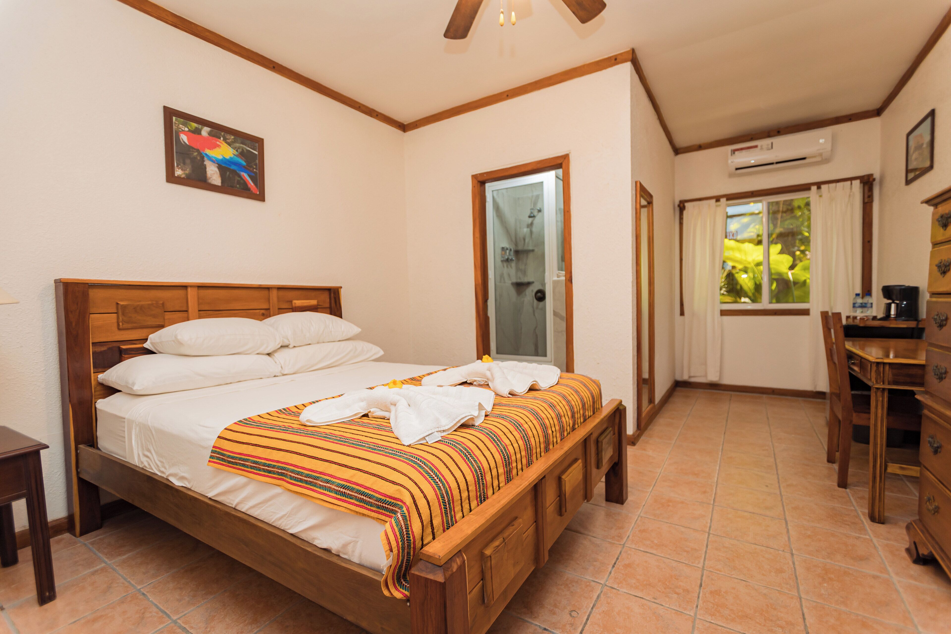 A bedroom with a wooden bed, a desk, and a chair.