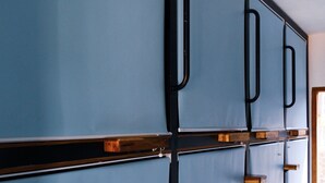 A row of blue lockers with wooden handles and metal frames. - Kaniu Capsule Hostel (Kuta)
