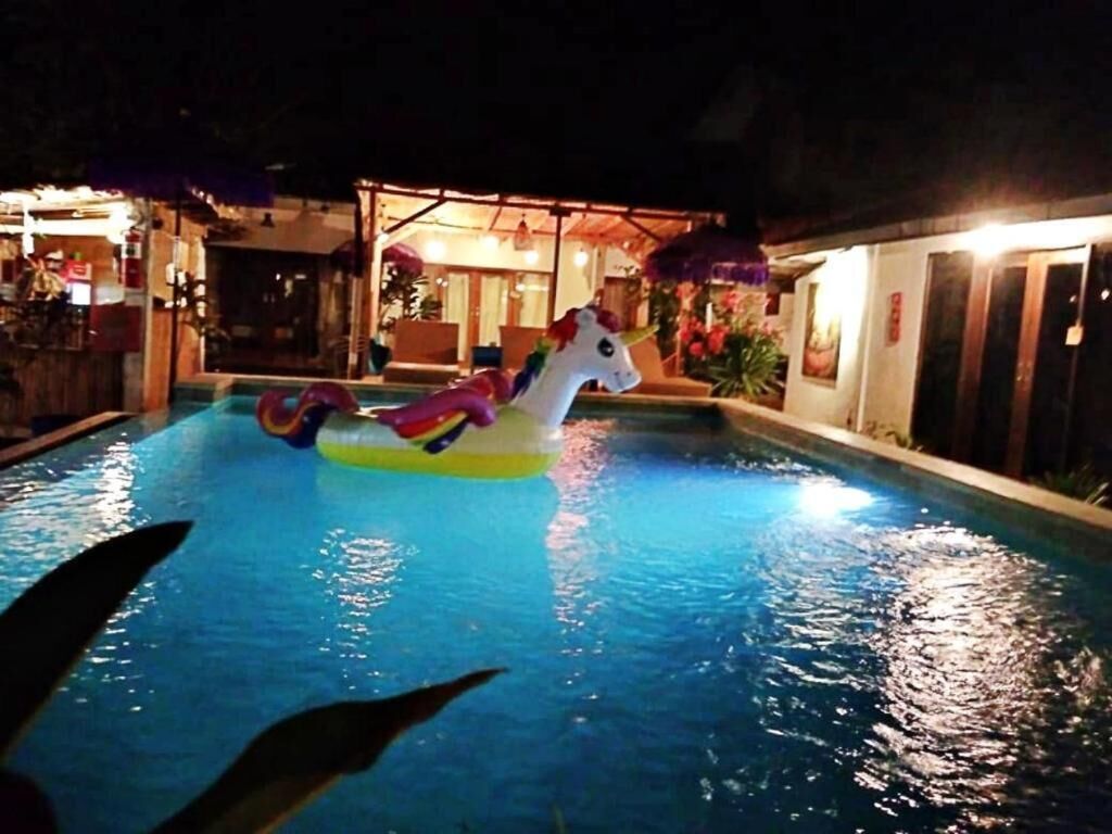 A swimming pool with a unicorn float.