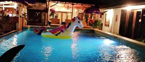 A swimming pool with a unicorn float.