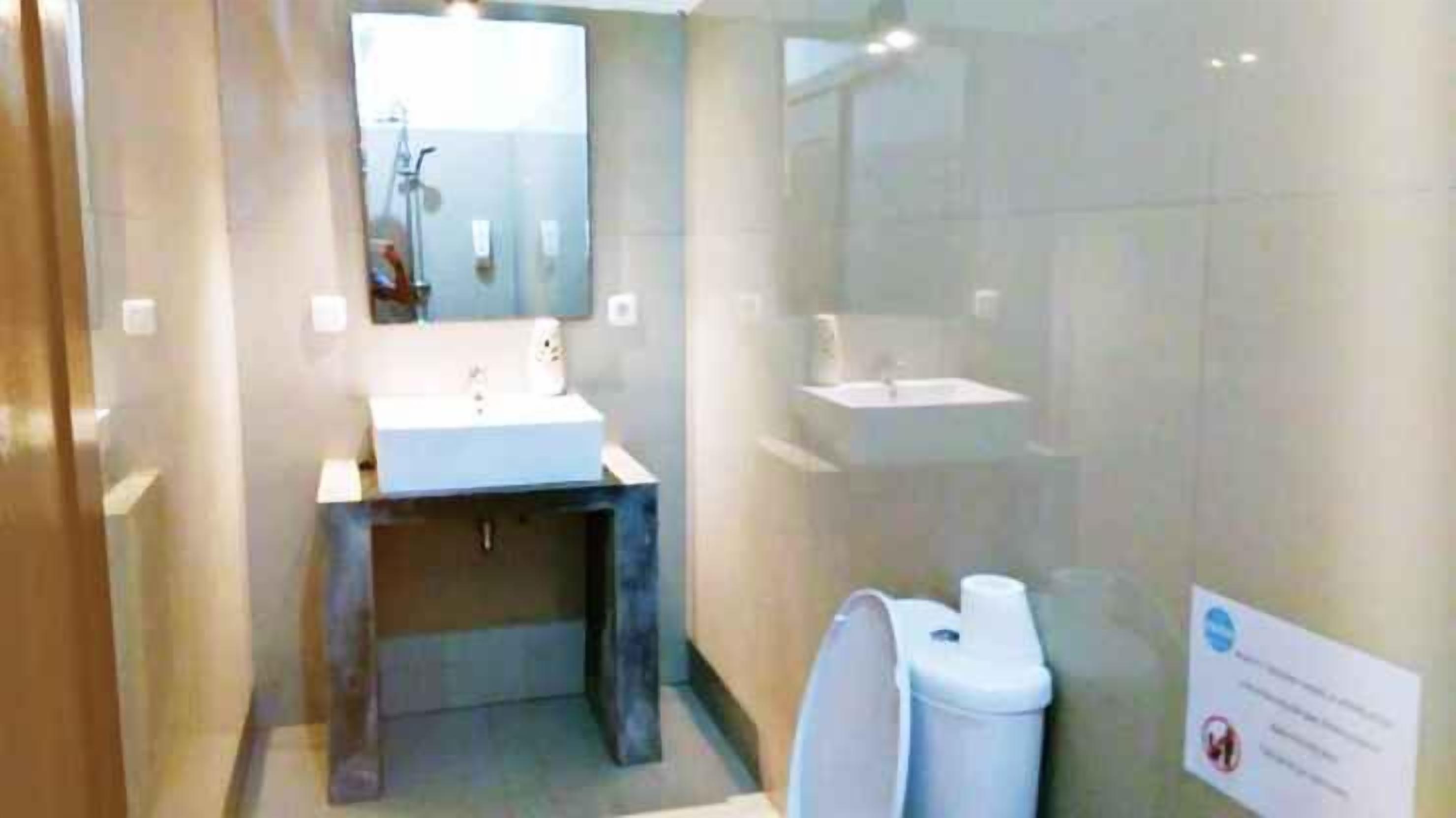 Une salle de bain moderne avec un lavabo, un miroir et un espace douche.