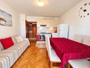 A compact living space with a kitchenette, a dining area, and a sofa. - Apartment Zdenka with three bedrooms (Njivice)