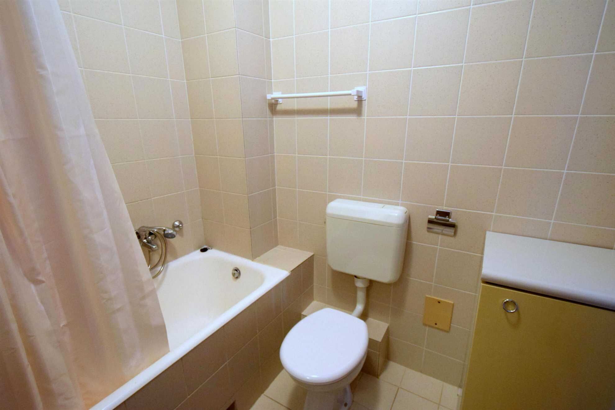 Et badeværelse med badekar, toilet og håndvask.