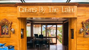 Entrada a una cabaña de madera con un letrero que dice 'Cabins By The Lake'.