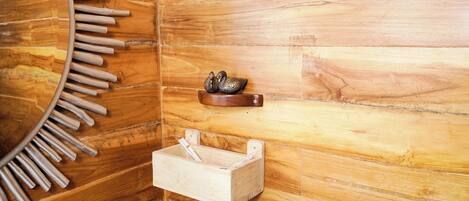 Una pared de madera con un estante de madera que sostiene objetos decorativos y una pequeña caja de madera.