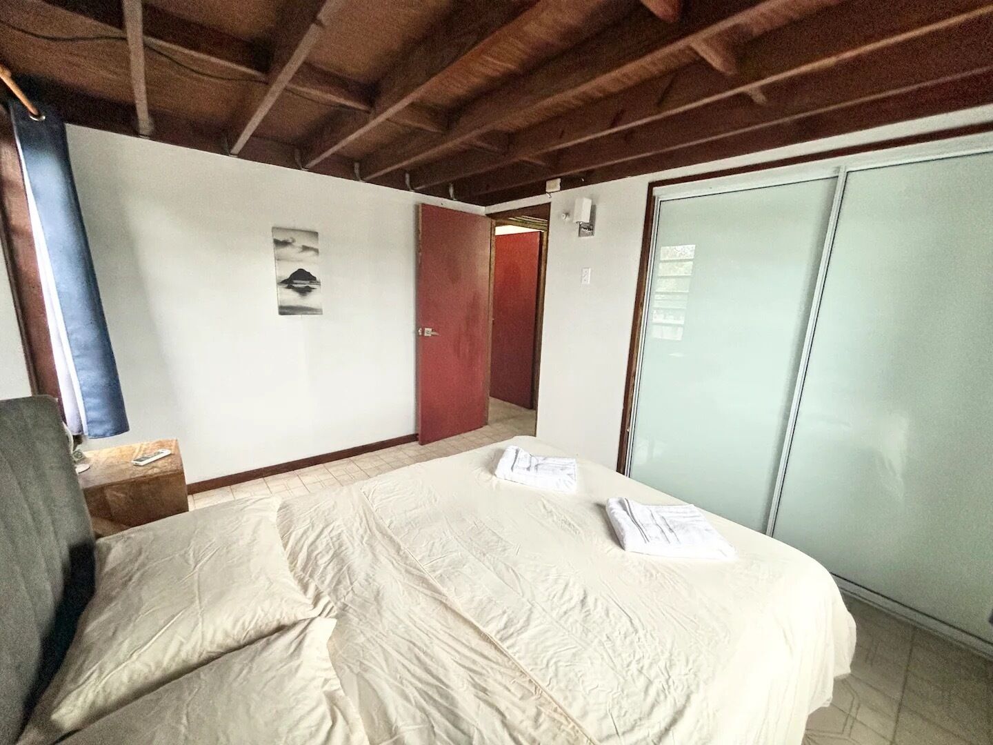 A hotel room with a bed, a wardrobe, and a door.