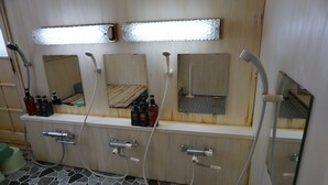 A bathroom with three sinks, each with a mirror above. There are bottles of toiletries on the counter, and the floor is tiled. - Tokiwatei (Hakuba)