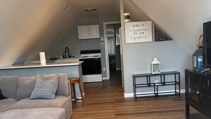 Avokeittiöllä, ruokailutilalla ja olohuoneella varustettu loft-tyylinen asunto.
