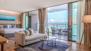 A modern hotel room with a bed, sofa, and a balcony with a view of the sea. - Prince Hotel Da Nang  (Da Nang)