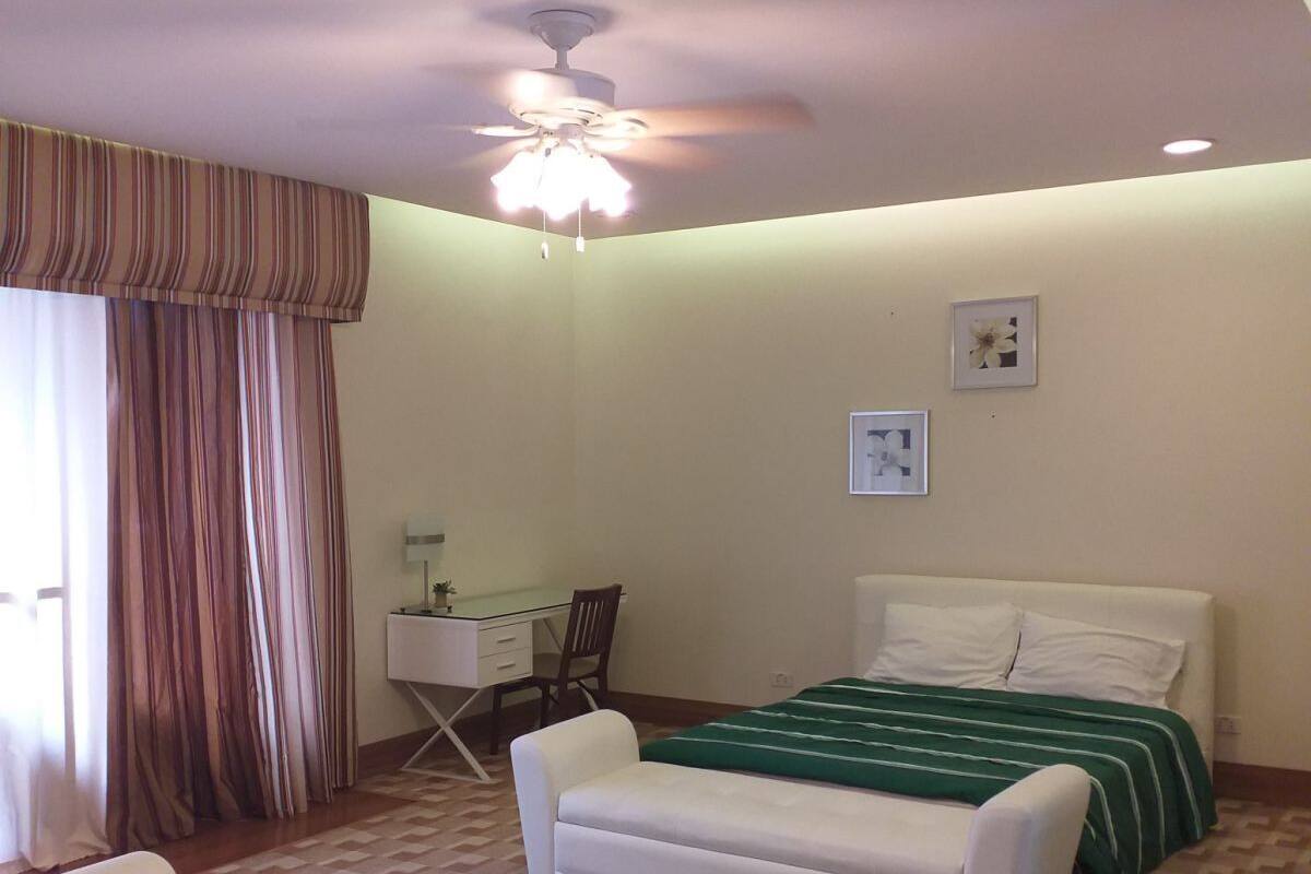 A bedroom with two beds, a desk, and a chair.