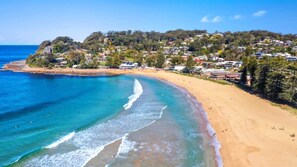 A coastal town with a sandy beach and clear blue waters. - Nirvana Court 3 - Beachfront Location (Avoca Beach)