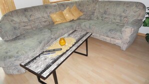 A living room with a patterned sofa, a small coffee table, and a framed picture on the wall. - Miranda by Interhome (Saas-Almagell)