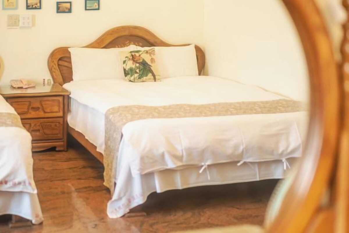 Un letto matrimoniale con testiera in legno, un comodino e una lampada da notte.