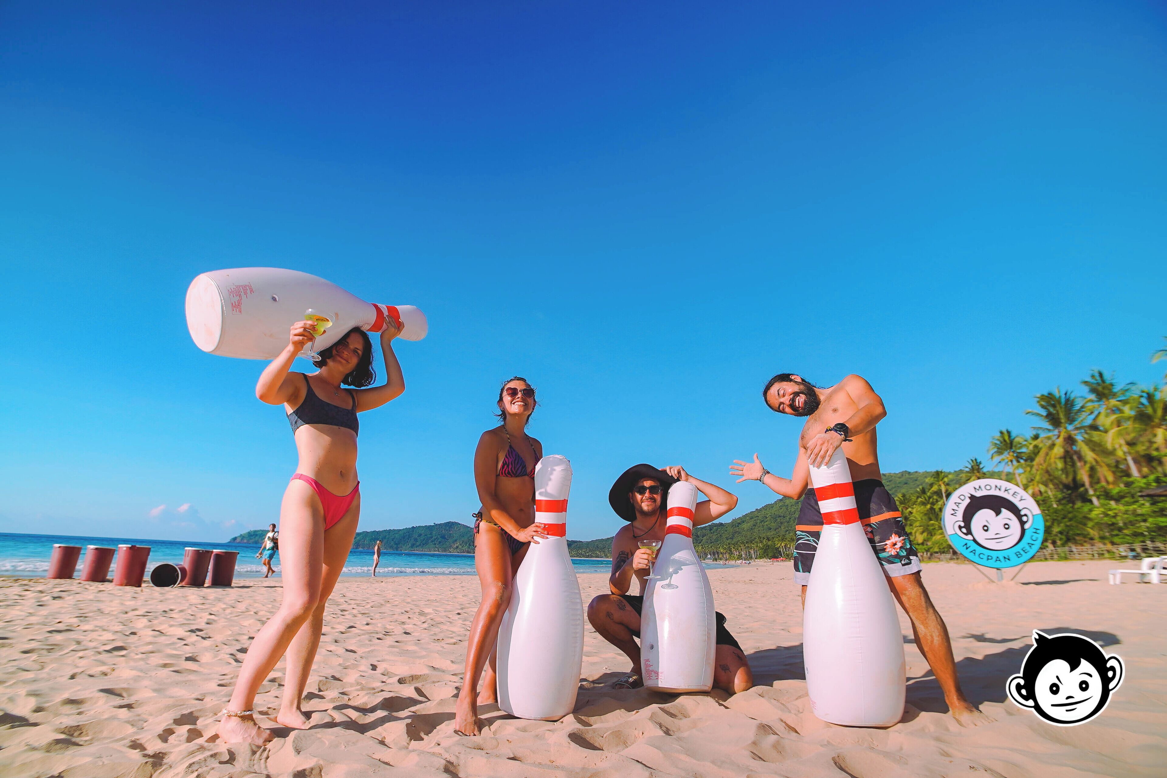 A beach scene with people and large white objects.