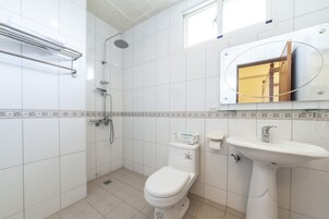 Un baño con inodoro, lavabo y ducha.