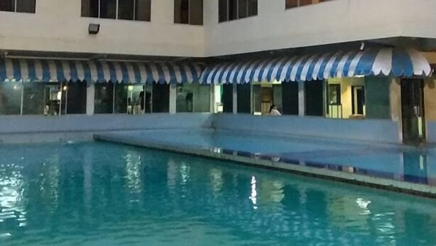 Um hotel com vários andares e piscina.