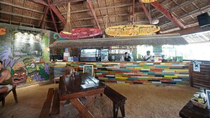 A restaurant with a colorful, multi-tiered counter and a rustic, thatched roof interior.