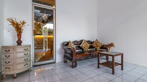 Un salon comprenant un canapé, une table basse, un meuble et un vase contenant des plantes séchées.