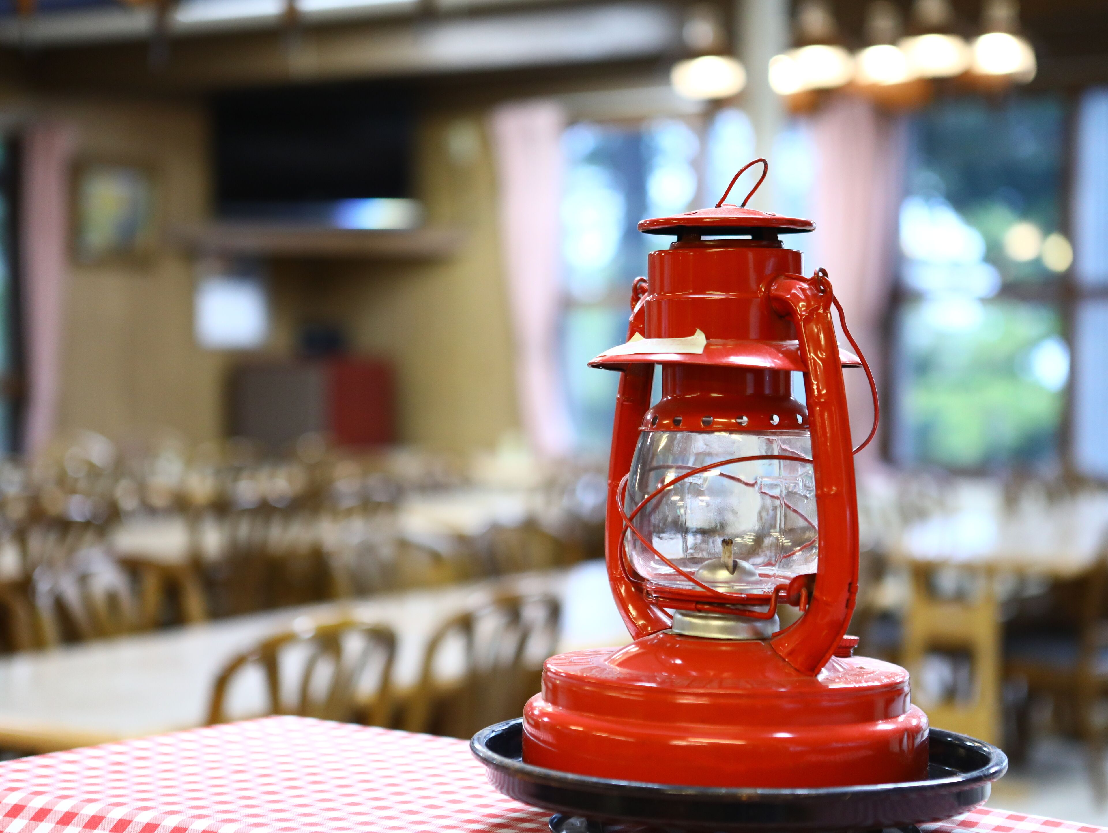 Un farol rojo sobre una mesa en un restaurante.