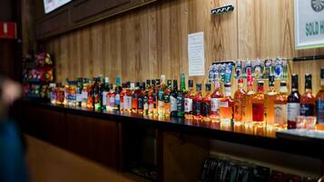 Un bar con diverse bottiglie di liquori e un cartello che indica una casa venduta.