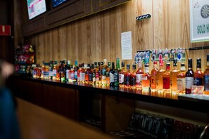 Un bar con una variedad de botellas de licor y un cartel que indica 'se vendió'.