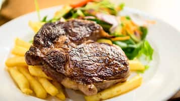 Una bistecca con patatine fritte e un'insalata su un piatto.