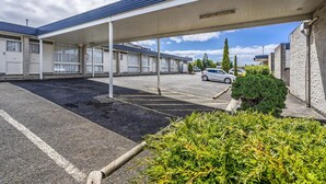 A motel with a covered parking area, multiple rooms, and a small parking lot. - Top of the Town Hotel Motel (Upper Burnie)