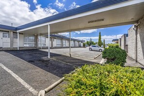 A motel with a covered parking area, multiple rooms, and a small parking lot. - Top of the Town Hotel Motel (Upper Burnie)