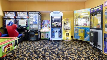 A row of arcade machines in a room with patterned carpet flooring.