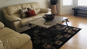 A living room with a sofa, a coffee table, a mirror, and a ceiling fan. - Cozy home near Sun Valley Resort! (Bellevue)