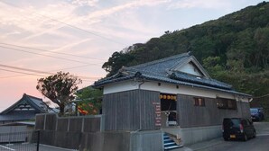 A traditional Japanese building with a tiled roof and a signboard listing amenities like a bar, cafe, and lunch. - Guest House & Bar Diamond Head (Mihama)