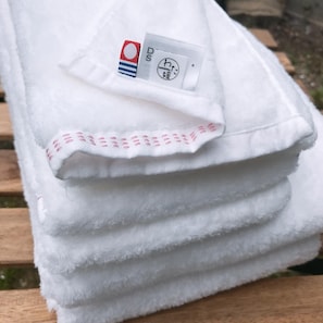 A stack of white towels with a label on the top towel.