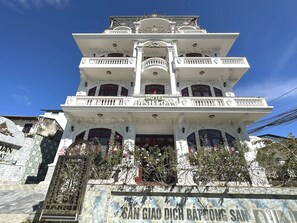 Un edificio de varios pisos con un letrero que dice "HOTEL DINH LOAN".