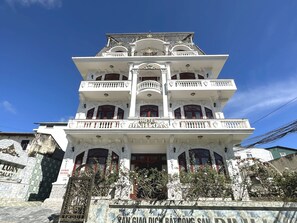 Un edificio de varios pisos con balcones y detalles arquitectónicos ornamentales.