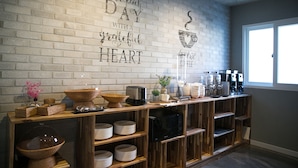 A kitchen area with a brick wall, wooden shelves, and various kitchen appliances. - Gray Hotel (Tongyeong)