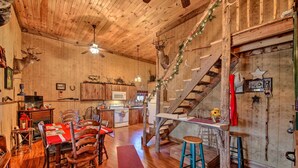 A rustic wooden interior with a dining area, kitchen, and a staircase. - 'The Bovard Lodge' Rustic Cabin Near Ohio River! (Florence)